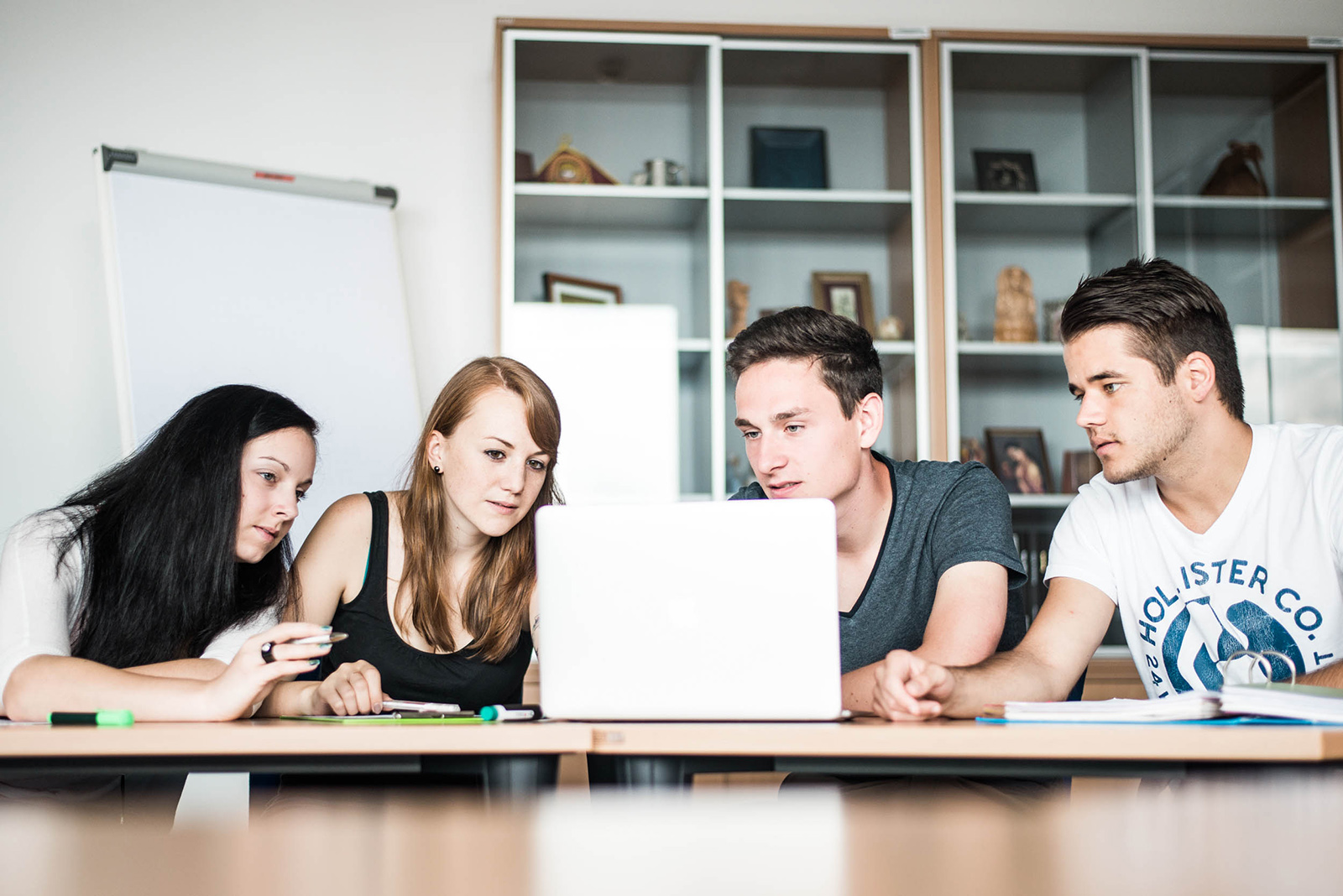 Vier FH Studenten lernen vor einem Laptop in einer Klasse